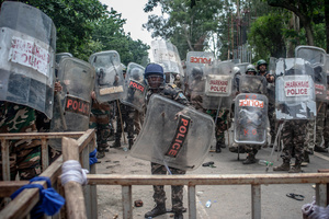 Police officers holding batons and protective shields stand in position during a confrontation with students. Students staged a march to the state assembly, amplifying ongoing protests against alleged irregularities in examinations conducted by the Jharkhand Public Service Commission and the Jharkhand Staff Selection Commission.