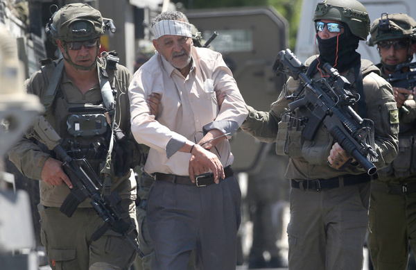 Israeli soldiers escort an elderly Palestinian detainee during a raid on Balata refugee camp, east of Nablus in the West Bank. Israeli military forces raided the central market during a security operation. Soldiers fired tear gas, causing dozens of Palestinians to suffer. Youths threw stones at the soldiers during the operation, and an elderly man was arrested.