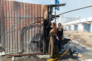 Two civilian women seen surveying the aftermath of a massive fire destroying the Pochayna book market following a nighttime military strike. On the night of August 16, 2026, a massive Russian air strike on Kyiv caused severe destruction and a large-scale fire at the "Pochaina" book market (formerly known as Petrivka) in the Obolon district. The enemy attack completely burned down several rows of trading pavilions containing books and stationery just ahead of the new school year. Emergency response teams worked at the scene to extinguish the blaze, which spread across a vast area. According to preliminary reports from city authorities, at least three people were injured as a result of the overnight attack. The destroyed marketplace had operated in the capital for nearly 30 years and stood as one of the largest hubs for book trade in Ukraine.