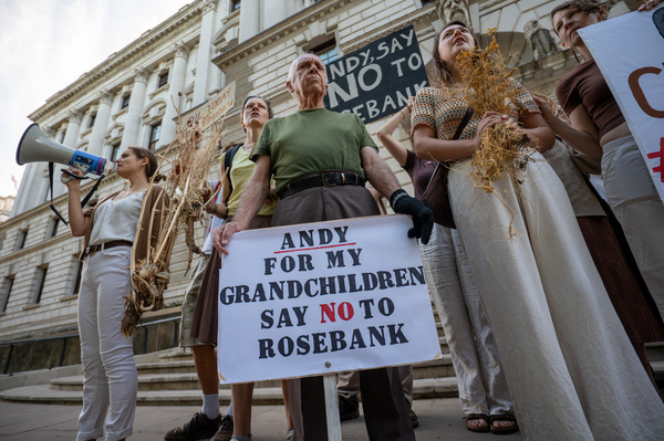 A Stop Rosebank activist holds a placard reading “Andy for my Grandchildren say no to Rosebank" during a demonstration outside the Treasury at Horse Guards road. Stop Rosebank activists staged a protest outside the Treasury highlighting the impact of prolonged heatwaves and drought on agriculture. Campaigners displayed empty harvesting baskets and a hessian sack labelled “Wheat – failed” to represent damaged crops and poor harvests. Individuals held placards which read “Oil Fuels Crop Failure”, “Rosebank Won’t Feed Britain” and “Burnham Say No To Rosebank”. The protest took place as the public consultation on the proposed Rosebank oil field closed with activists calling for the project to be rejected.