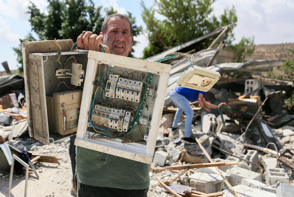 A Palestinian homeowner holds the electrical panel of his house after it was demolished by Israeli army bulldozers in the village of Beit Dajan, east of Nablus in the West Bank. Israeli forces demolished the homes and three agricultural buildings, claiming they were built in Area C. This comes after the demolition of homes in the Qalandiya refugee camp near Jerusalem.