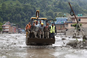 Security personnel rescue people in a bulldozer from buildings that were damaged along the swollen Trishuli River following a massive flash flood triggered by an avalanche of ice and rock in the upper Lhende River on the Tibetan side. The sudden flood swept through communities along the Bhote Koshi and Trishuli river, destroying homes, roads and bridges and leaving a widespread devastation downstream.