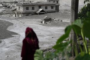 A woman looks at the building that was damaged along the swollen Trishuli River following a massive flash flood triggered by an avalanche of ice and rock in the upper Lhende River on the Tibetan side. The sudden flood swept through communities along the Bhote Koshi and Trishuli river, destroying homes, roads and bridges and leaving a widespread devastation downstream.