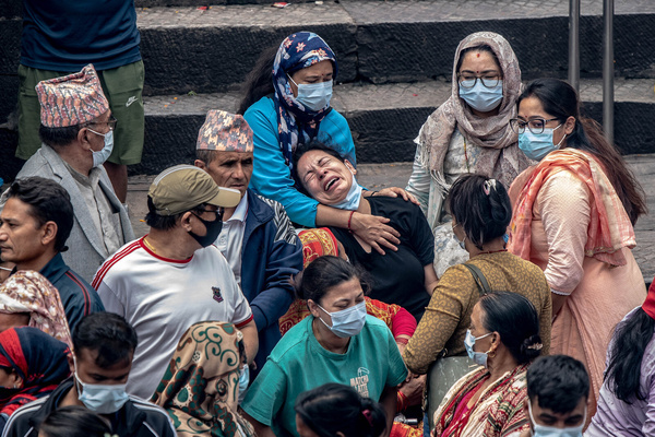 A woman cries as relatives carry Kush grass effigies representing missing flood victims during symbolic Hindu cremation rites at Pashupatinath Temple in Kathmandu. Families held the ceremonies to honor and liberate the souls of loved ones lost after deadly flash floods devastated villages in the region a week prior.