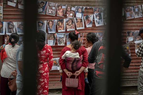 (EDITOR's NOTE: Image depicts death)
Relatives stand in the rain beside posters of unidentified deceased flash-flood victims outside Tribhuvan University Teaching Hospital (TUTH) in Kathmandu, where the images have been displayed to help families identify their missing loved ones following devastating floods caused by heavy rainfall.