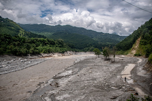Nuwakot district is almost entirely cut off and paralyzed after catastrophic flash floods, triggered by upstream glacier collapse, annihilated infrastructure, including this crucial asphalt road section, in Trishuli. The widespread erosion and massive surge of mud have fundamentally altered the landscape and severed critical connectivity, isolating survivors across the devastated district and making a mockery of any recovery timeline as thousands face displacement.