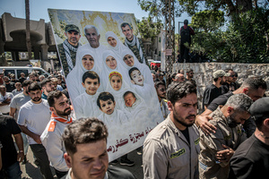 Mourners carry pictures of those killed in Kfar Roummane, southern Lebanon, during the funeral of a family killed by an Israeli airstrike. At least 4,381 people were killed and 12,402 wounded by Israeli attacks in Lebanon between March 2 and September 7, 2026, according to Lebanon's ministry of health.