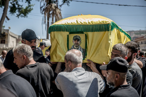 A coffin draped in a Hezbollah flag is carried to a cemetery in Kfar Roummane, during the funeral of a family killed by an Israeli airstrike. At least 4,381 people were killed and 12,402 wounded by Israeli attacks in Lebanon between March 2 and September 7, 2026, according to Lebanon's ministry of health.