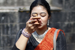 A woman prays during the Teej festival at Pashupatinath Temple. Married and unmarried Hindu women observe fasting during the festival. Married women traditionally abstain from food and water while praying for the longevity, peace, and prosperity of their husbands and families, while unmarried women fast in the hope of being blessed with good husbands.