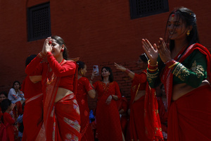 Women dance during the Teej festival at Pashupatinath Temple. Married and unmarried Hindu women observe fasting during the festival. Married women traditionally abstain from food and water while praying for the longevity, peace, and prosperity of their husbands and families, while unmarried women fast in the hope of being blessed with good husbands.
