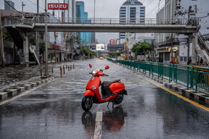 A motorcycle is parked on a dry section of Phetchaburi bridge as floodwater blocks the way ahead in Bangkok. Floodwaters inundate major roads, including Phetchaburi Road and the Pridi Banomyong neighborhood in Bangkok, following a record monsoon downpour that prompted a capital-wide disaster declaration. Municipal pumps operate at full capacity to drain overflowing canals.