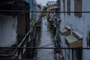 Floodwater fills a narrow lane between buildings in the Pridi area of Bangkok. Floodwaters inundate major roads, including Phetchaburi Road and the Pridi Banomyong neighborhood in Bangkok, following a record monsoon downpour that prompted a capital-wide disaster declaration. Municipal pumps operate at full capacity to drain overflowing canals.