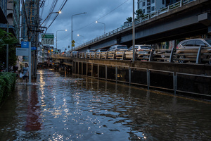 Vehicles line an elevated road as floodwater covers the street below in the Pridi area of Bangkok. Floodwaters inundate major roads, including Phetchaburi Road and the Pridi Banomyong neighborhood in Bangkok, following a record monsoon downpour that prompted a capital-wide disaster declaration. Municipal pumps operate at full capacity to drain overflowing canals.