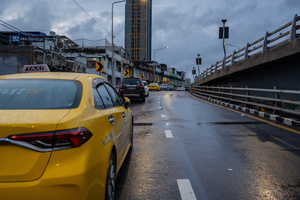 Cars are parked along a bridge above flooded streets in the Pridi area of Bangkok. Floodwaters inundate major roads, including Phetchaburi Road and the Pridi Banomyong neighborhood in Bangkok, following a record monsoon downpour that prompted a capital-wide disaster declaration. Municipal pumps operate at full capacity to drain overflowing canals.