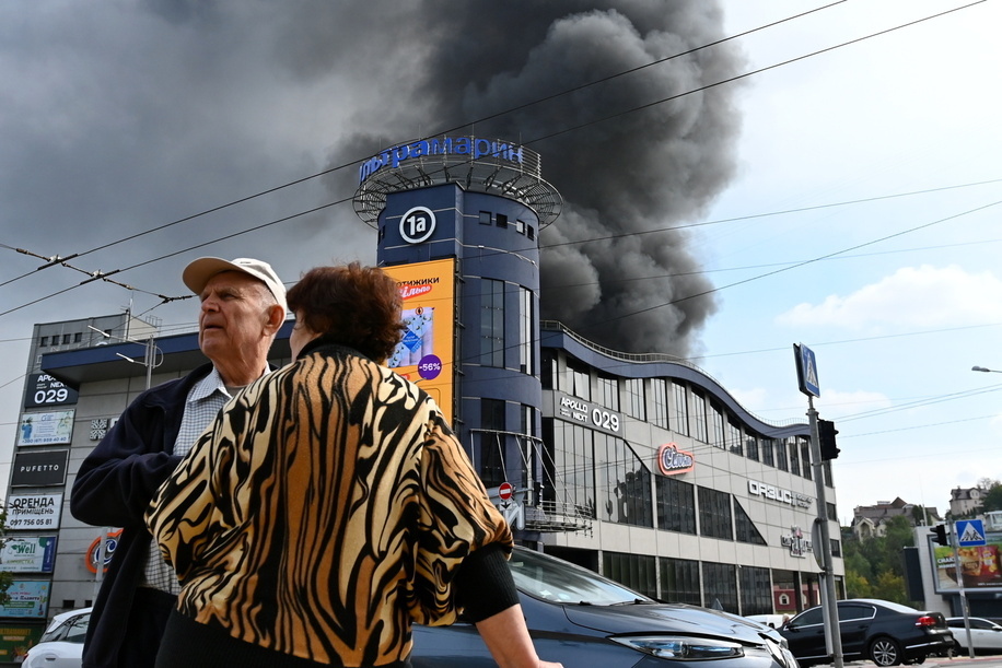 An elderly couple stands against the backdrop of smoke rising from an office building following Russian drone strikes during Russia's attack on Ukraine. Russia massively shells Kyiv with missiles and drones. At least eight people were injured, and one died in the hospital. Explosions echoing across downtown Kyiv every 15 to 30 minutes. Air attacks triggered fires at a gas stations, transport enterprises and warehouses. Drone strikes hit civilian and infrastructure objects in the Holosiivskyi and Solomyanskyi districts which left four victims hospitalized.