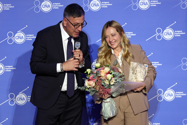 Italian Prime Minister (R) Giorgia Meloni receives a bouquet of flowers and an award from CNA President (L) Dario Costantini during the celebration at the Auditorium Antonianum. Celebrations marking the 80th anniversary of the CNA (National Confederation of Crafts and Small and Medium Enterprises) were held at the Auditorium Antonianum. Prime Minister Giorgia Meloni attended the event which is dedicated to the world of Italian craftsmanship and small and medium-sized enterprises.