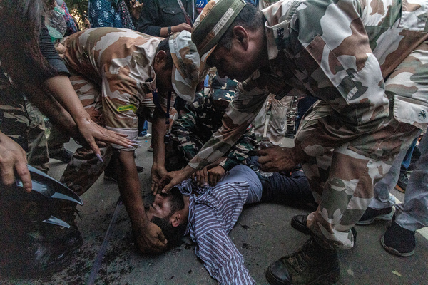 Police officers surround a demonstrator who fainted during detentions at an opposition protest. The demonstration, led by the Cockroach Janta Party (CJP) and supported by the INDIA bloc, demands the resignation of Chief Election Commissioner Gyanesh Kumar over alleged voter roll deletions and irregularities during recent electoral revisions, charges the Election Commission denies.