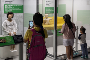 A visitor takes a photo of Japanese 'Kodomoroid' during the 'ROBOTS' exhibition at the Hong Kong Science Museum in Hong Kong on May 8, 2021. The exhibition explores the 500-year story of humanoid robots and the artistic and scientific quest to understand what it means to be human.