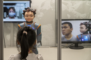 A visitor interacts with a robot during the 'ROBOTS' exhibition at the Hong Kong Science Museum in Hong Kong on May 8, 2021. The exhibition explores the 500-year story of humanoid robots and the artistic and scientific quest to understand what it means to be human.