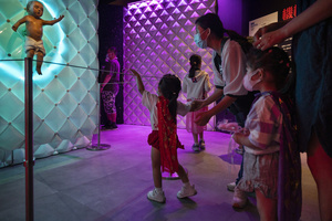 A young visitor points at the 'Animatronic baby' robot during the 'ROBOTS' exhibition at the Hong Kong Science Museum in Hong Kong on May 8, 2021. The exhibition explores the 500-year story of humanoid robots and the artistic and scientific quest to understand what it means to be human.