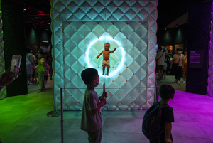 Young visitors walk past the 'Animatronic baby' robot during the 'ROBOTS' exhibition at the Hong Kong Science Museum in Hong Kong on May 8, 2021. The exhibition explores the 500-year story of humanoid robots and the artistic and scientific quest to understand what it means to be human.