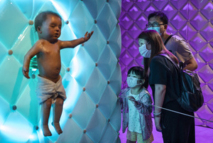 Visitor look at the 'Animatronic baby' robot on displayed during the 'ROBOTS' exhibition at the Hong Kong Science Museum in Hong Kong on May 8, 2021. The exhibition explores the 500-year story of humanoid robots and the artistic and scientific quest to understand what it means to be human.