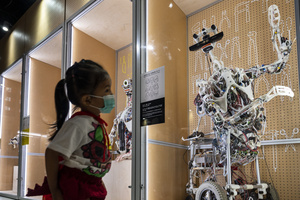 A young visitor walks past robots on displayed during the 'ROBOTS' exhibition at the Hong Kong Science Museum in Hong Kong on May 8, 2021. The exhibition explores the 500-year story of humanoid robots and the artistic and scientific quest to understand what it means to be human.