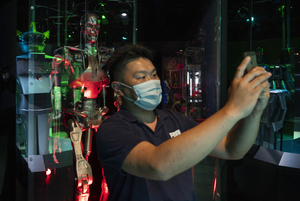 A visitor takes a selfie with the T-800 Endoskeleton robot used in filming 'Terminator Salvation' during the 'ROBOTS' exhibition at the Hong Kong Science Museum in Hong Kong on May 8, 2021. The exhibition explores the 500-year story of humanoid robots and the artistic and scientific quest to understand what it means to be human.