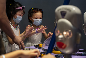 Young visitors play with 'Electrototo' robots during the 'ROBOTS' exhibition at the Hong Kong Science Museum in Hong Kong on May 8, 2021. The exhibition explores the 500-year story of humanoid robots and the artistic and scientific quest to understand what it means to be human.