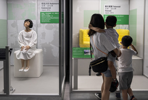 A family look at robots on displayed during the 'ROBOTS' exhibition at the Hong Kong Science Museum in Hong Kong on May 8, 2021. The exhibition explores the 500-year story of humanoid robots and the artistic and scientific quest to understand what it means to be human.
