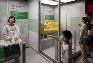 A young visitor points at the Japanese 'Kodomoroid' during the 'ROBOTS' exhibition at the Hong Kong Science Museum in Hong Kong on May 8, 2021. The exhibition explores the 500-year story of humanoid robots and the artistic and scientific quest to understand what it means to be human.