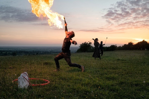 A fire breather entertains people on the Hill of Tara at the last moments before the sun sets on the longest day in the Northern Hemisphere.
A large number of spectators, young and old, many accompanied with dogs, gathered at the Hill of Tara in Co. Meath to view the sunset on the June 21st Summer Solstice. The Hill of Tara is a Neolithic passage grave and is a site of important ancient historical significance in Irish folklore.