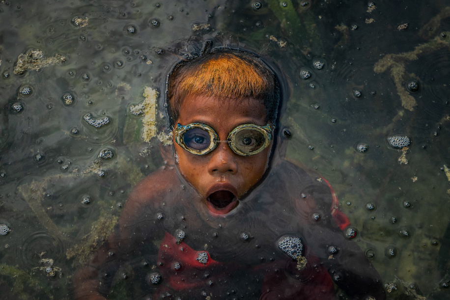 Dimas Saputra (10 years old) seen swimming in the sea.
The life of the Bajo tribe, from birth to adulthood, is dependent on the sea. Everything is done there, from looking for food to all life activities carried out in the sea. Dimas Saputra is one of the many children who became an accomplished bajo child with extraordinary diving skills at a young age. Since childhood, his father Muhammad Ajran (36 years old) and his mother Sunarti (35 years old) have been accustomed to knowing and uniting with nature.