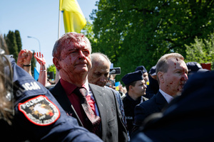 The Ambassador of Russian Federation Sergey Andreev, surrounded by a Polish police guard, moves towards his car covered with fake blood. On the 77th anniversary of the Red Army victory over Nazi Germany Ukrainian activists performed at the Soviet soldiers cemetery in Warsaw as they protested against Russian invasion of Ukraine. Activists banned the Russian delegation headed by Sergey Andreev, the Ambassador of the Russian Federation in Poland, from entering the Cemetery. During that attempt diplomats were doused with fake blood by the Ukrainian activists.
