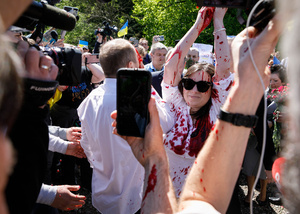 Irina Zamlyan uses fake blood as she performs near the Russian Ambassador Sergey Andreev (not seen in the photo). On the 77th anniversary of the Red Army victory over Nazi Germany Ukrainian activists performed at the Soviet soldiers cemetery in Warsaw as they protested against Russian invasion of Ukraine. Activists banned the Russian delegation headed by Sergey Andreev, the Ambassador of the Russian Federation in Poland, from entering the Cemetery. During that attempt diplomats were doused with fake blood by the Ukrainian activists.