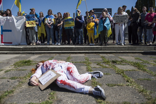 An activist lies on the ground as they symbolize the civilian victims of the war in Ukraine. Hundreds of Ukrainians and Polish activists protested at a Warsaw cemetery to Red Army soldiers who died during World War II. Russia's ambassador to Poland, Sergey Andreev, was hit with red paint by protesters opposed to the war in Ukraine at an annual Victory Day event commemorating the end of World War II. Ambassador Sergey Andreev arrived at the Soviet soldiers cemetery to lay flowers on Victory Day, but the diplomat and his delegation were forced to leave the area, accompanied by police officers.