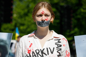 A protester with lips sealed with tape takes part during the protest. On the 77th anniversary of the Red Army victory over Nazi Germany Ukrainian activists performed at the Soviet soldiers cemetery in Warsaw as they protested against Russian invasion of Ukraine. Activists banned the Russian delegation headed by Sergey Andreev, the Ambassador of the Russian Federation in Poland, from entering the Cemetery. During that attempt diplomats were doused with fake blood by the Ukrainian activists.