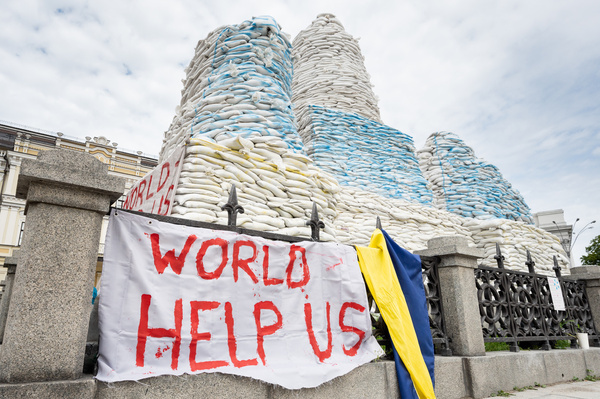 A banner that reads "World help us" near sandbags stacked around the Princess Olga Monument (near St. Michael's Golden-Domed Monastery) to protect it during the Ukrainian Russian war.