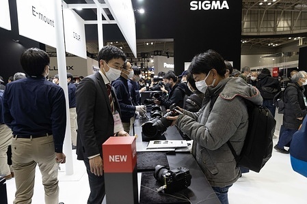 SIGMA exhibitor explains their company’s products to a visitor at CP+ Camera & Photo Imaging Show 2023 in Pacifico Yokohama National Convention Center.