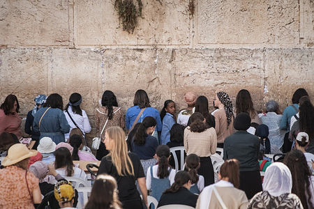 Female Jewish worshippers pray at the Western Wall. The Western Wall, also known as the Wailing Wall or Al Buraq Wall, is a pilgrimage site for Jewish believers in the Old City of Jerusalem. It is part of the Temple Mount's retaining wall and is divided by a partition, with men on the left and women on the right. Jewish visitors pray, read from the Torah, and leave handwritten notes, known as kvitlachim, in the wall’s cracks. This centuries-old tradition is based on the belief that a divine presence resides in the wall. The area is monitored by Israeli soldiers.