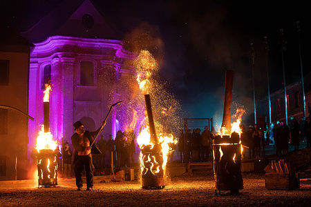 Fire artist performs to entertain the crowd during the street show "Snake Queen" at the town square during the holiday in Maribor.