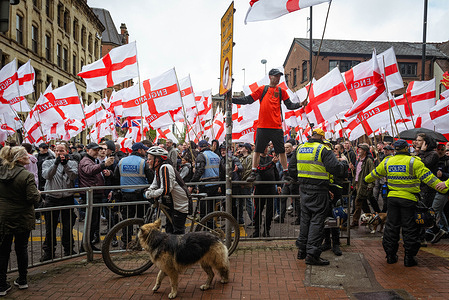 A man flying a st Georges flag joins the Britain First march for St. George's Day. Hundreds of people joined Paul Golding to parade around the city centre. They were met with a counter-protest by anti-racism groups and trade unions opposing the movement due to the party's rhetoric on immigration.
