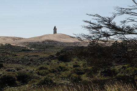 Rubjerg Knude Lighthouse (Rubjerg Knude Fyr) is one of North Jutland's major tourist attractions. The lighthouse is 23 m high. It is close by the fishing village, Lønstrup in north Jutland, Hjørring Municipality. In 2019 it was decided to try to move the lighthouse. The project was given to a local builder, Murer Kjeld, people gathered at Rubjerg Knude to attend this unique event. Over 20,000 showed up to watch the nearly 30-meter-high lighthouse roll on rails, 70 meters further inland.