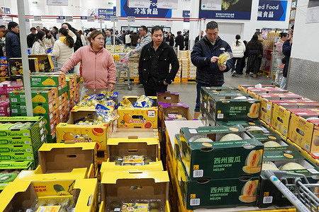 Shoppers select fresh fruits, including honeydew melons and kiwis, at the busy produce section of Sam's Club.