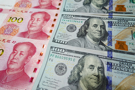 In this photo illustration, 100 US dollar notes and 100 RMB notes seen displayed.