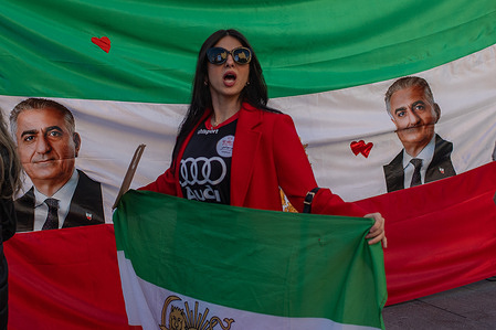 A pro-Iranian demonstrator carries an Iranian flag during the demonstration. Demonstration was held in Callao Square by Iranians residing in Madrid. They demand an end to the Islamist theocracy of the ayatollahs.