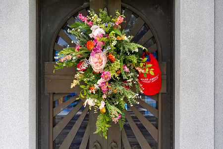 A Maga hat hangs on the door of a mausoleum at the Lake Lawn Metairie Cemetery.