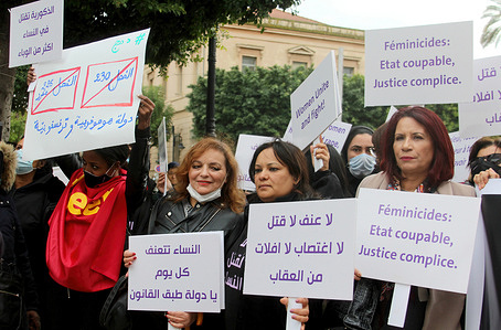 Protesters hold placards during a silent march denouncing violence against women along Avenue Habib Bourguiba in the centre of Tunisia.