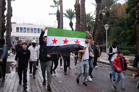 A group of Syrians marches with the Syrian National Army flag. The fall of Bashar al-Assad's government and the entry of Hayat Tahrir al-Sham into Damascus has sparked celebrations among Syrian refugees in Turkey. In Izmir, Syrians took to the streets to express their joy over the political shift. The demonstration reflects the deep significance of the change for refugees who have been living in Turkey for years. The mood in the streets was one of hope, as many Syrians see this development as a potential turning point for their country.