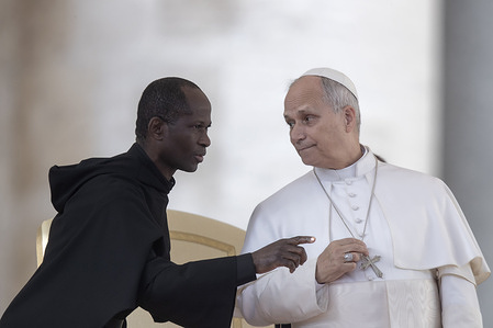Pope Leo XIV speaks with Father Edward Daniang Daleng, Vice Regent of the Papal Household during his weekly general audience in St. Peter's square at the Vatican.
